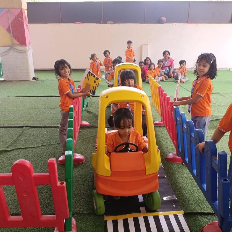 Children riding toy cars on a pretend road