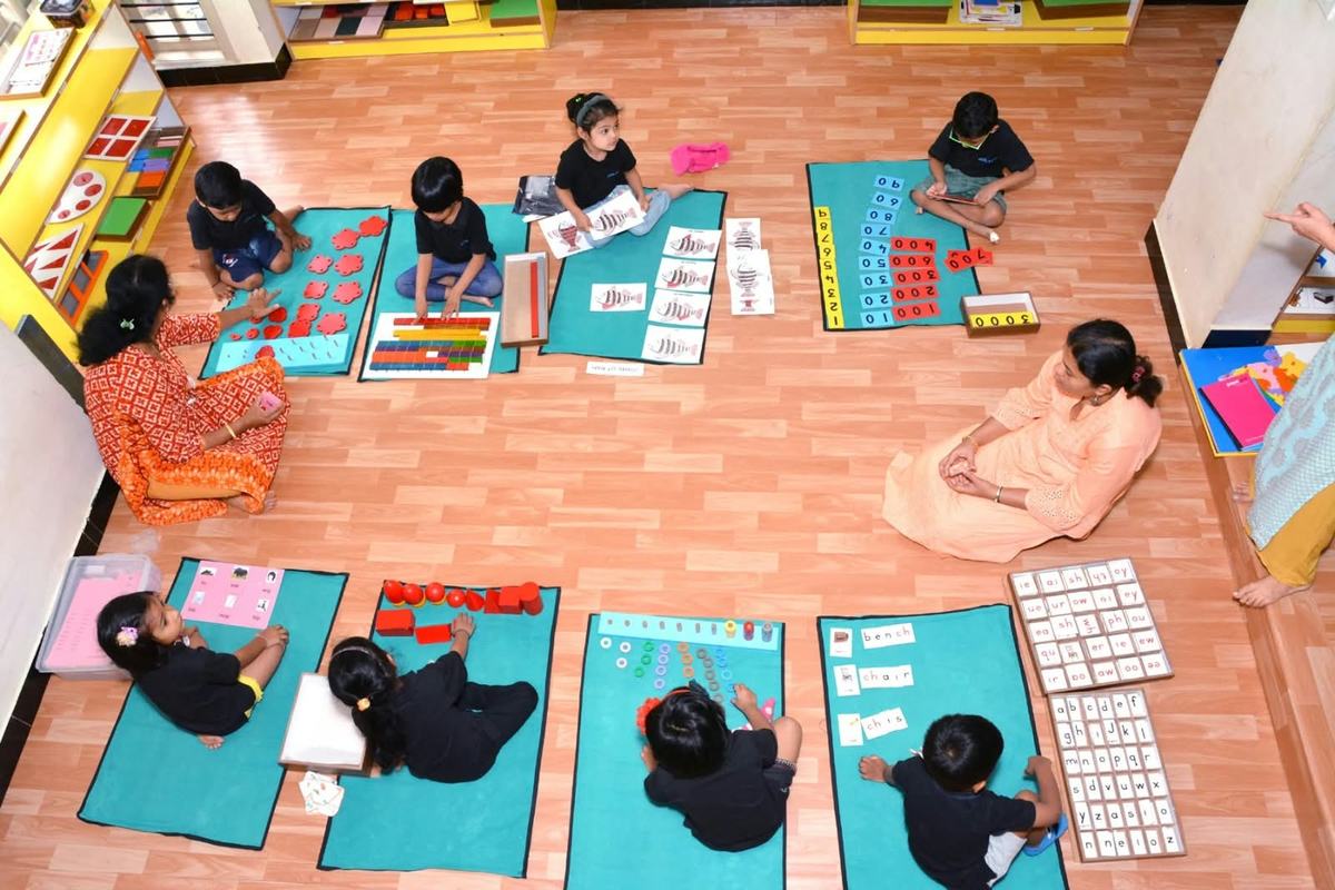 Children working with Montessori materials guided by educators